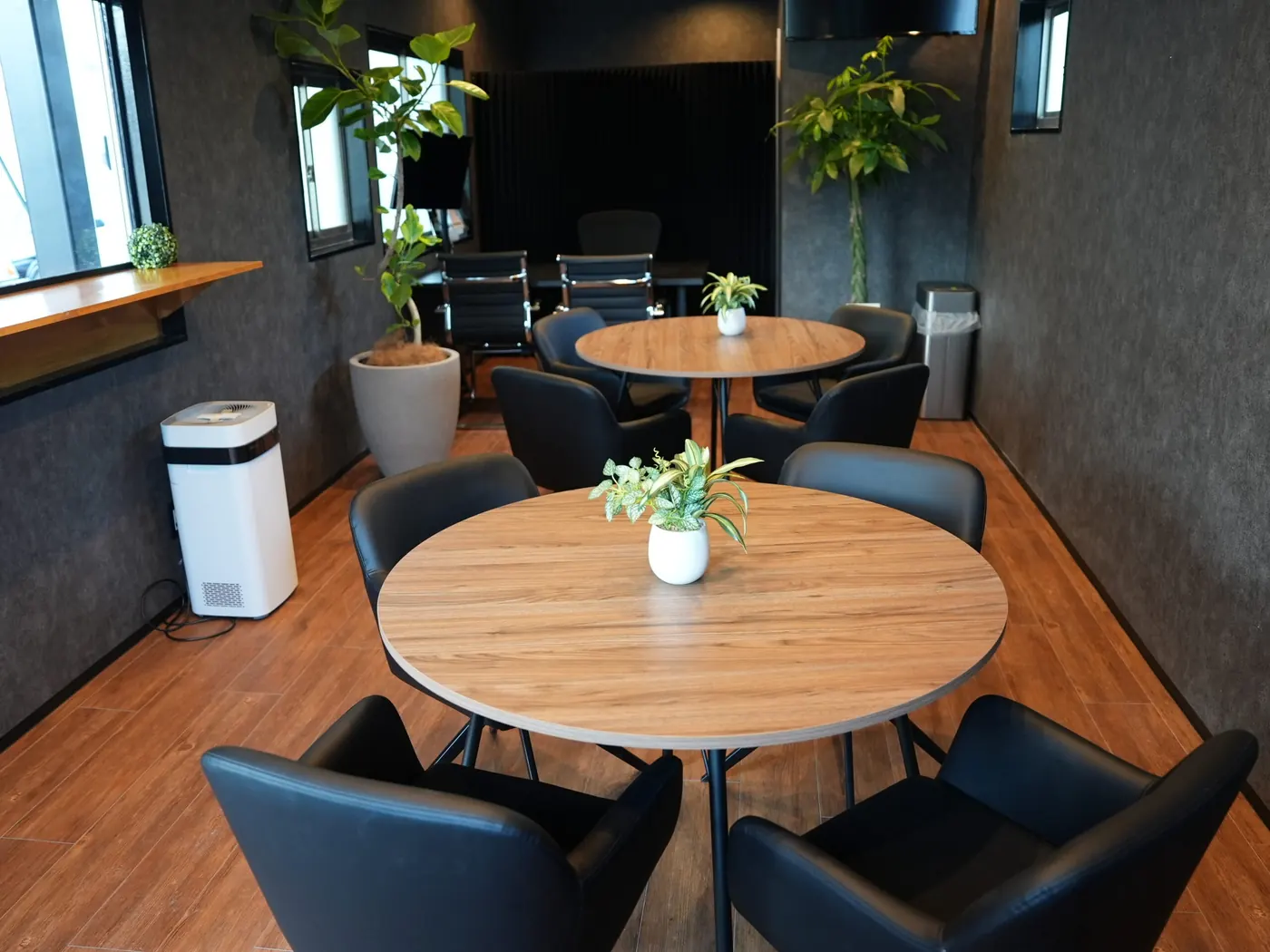 木製テーブルと黒いチェアを備えたMIYABI京都伏見本店の待合室